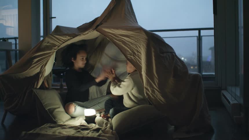 Children play in the tent in the living room