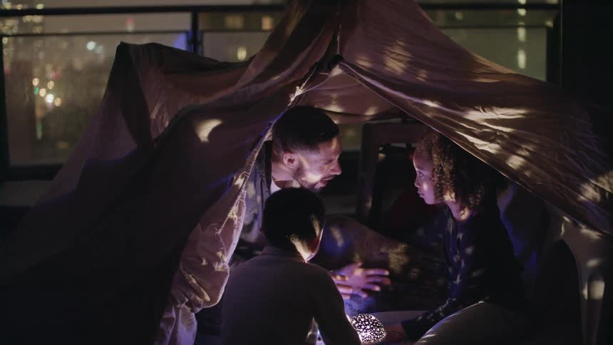 A father talking to his children in a tent