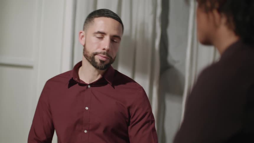A man sitting down indoors having a conversation with a woman in front of him