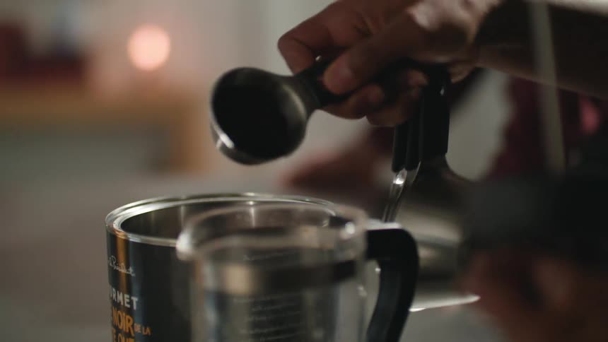 A woman prepares coffee as her children and husband sit at the counter