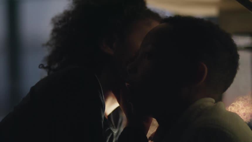 A young girl whispering into her brothers ear at night