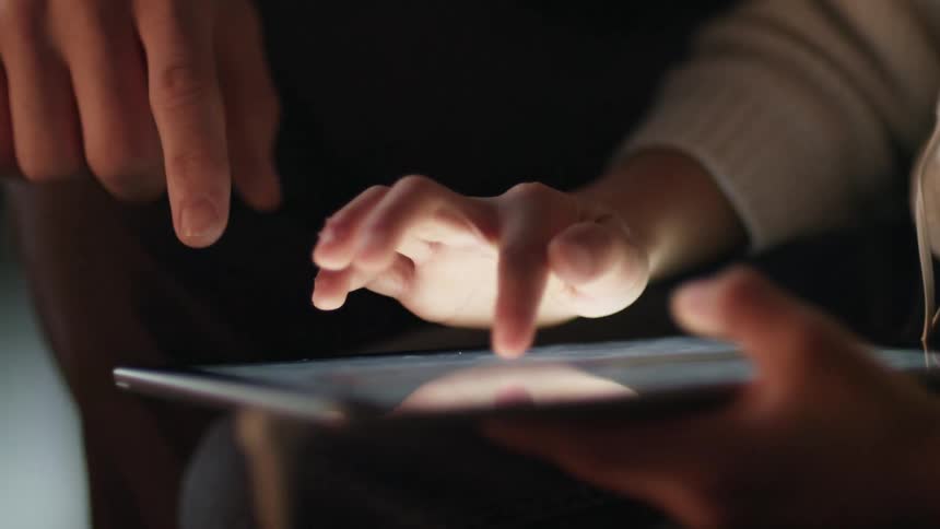 A child and adult using a tablet computer