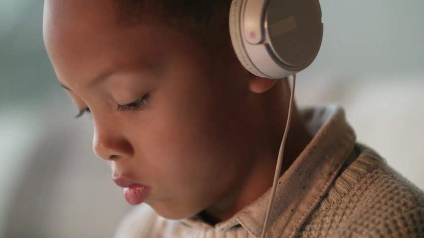 A girl is listening to music and wearing headphones indoors