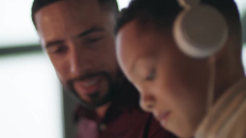 A father and son sitting around with the son wearing headphones