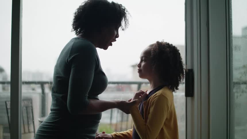 A mother is talking to her daughter indoors