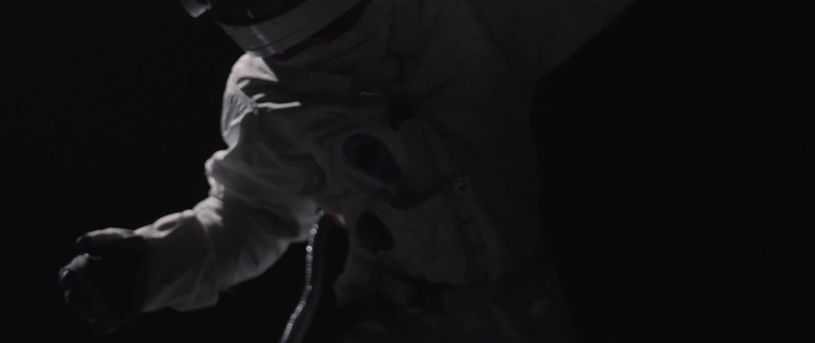 A person turns around in a space suit