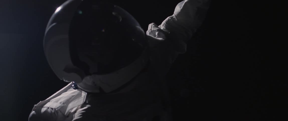 An astronaut is floating in a black area