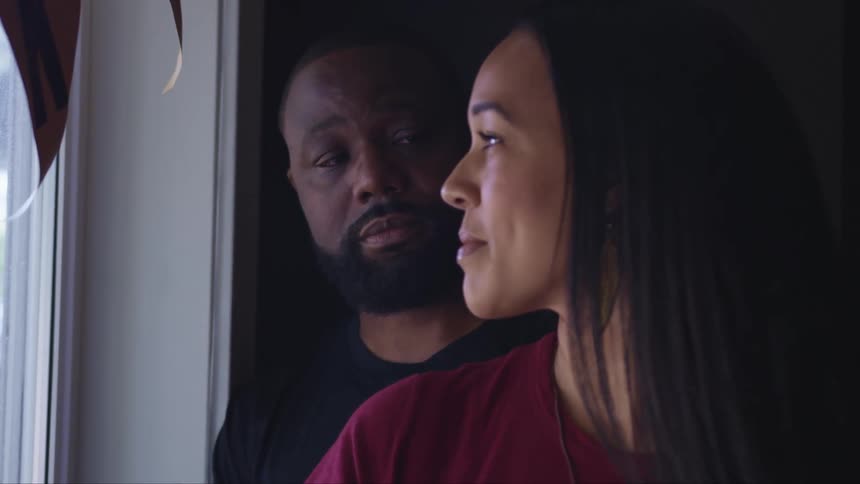 A man and woman are smiling at each other indoors