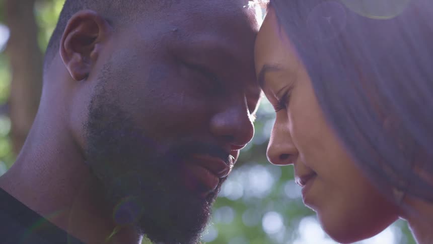 Young couple touching foreheads with their eyes closed outdoors