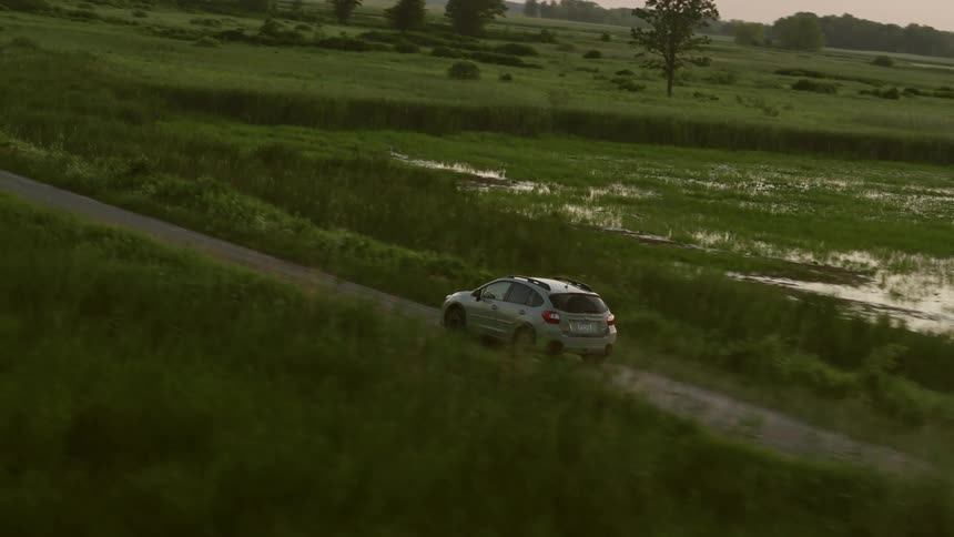 Ilver van is traveling on rural road past a swamp