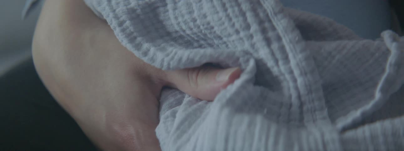 Mother holding baby wrapped in a blanket on her hands