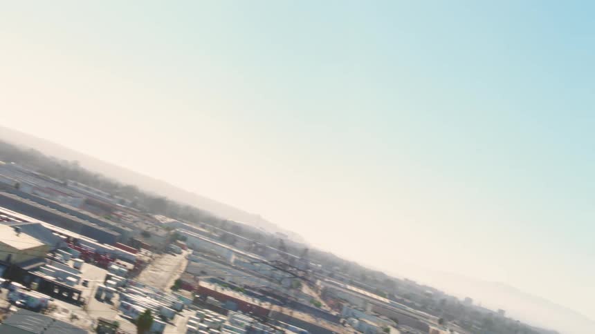 A city with a water tower with buildings trees the sky and clouds in the background