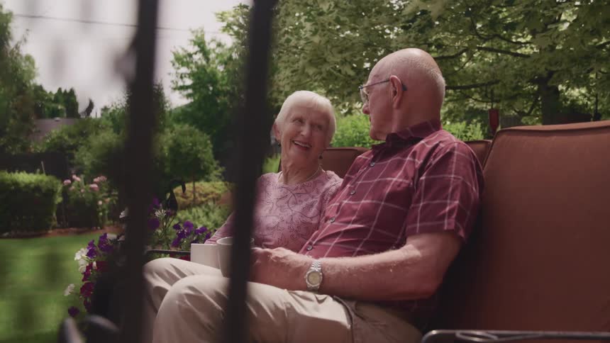 A husband and wife sitting on a bench together