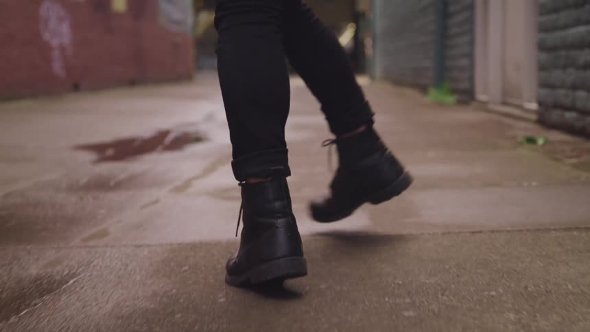 A person is walking in an alley during the day