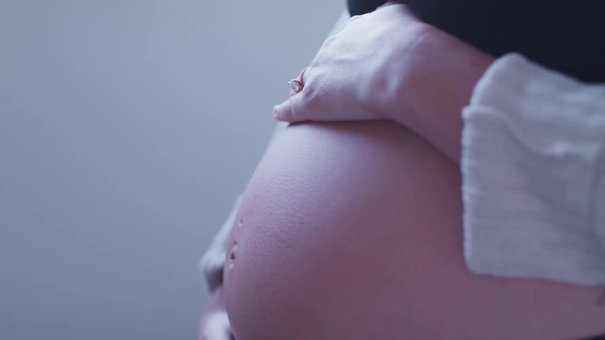 Close up of a woman rubbing her pregnant belly