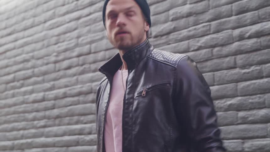 A frustrated man pacing with a book and pencil outside