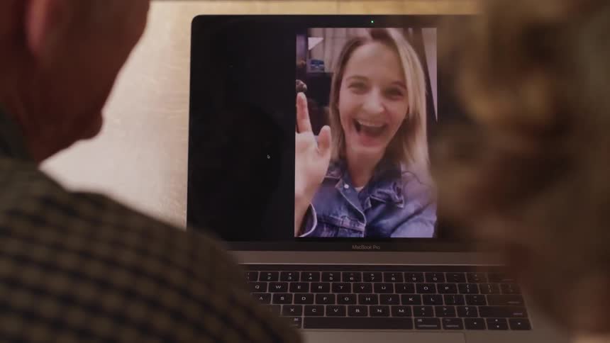 An elderly couple waving to their blonde daughter while video chatting on a laptop