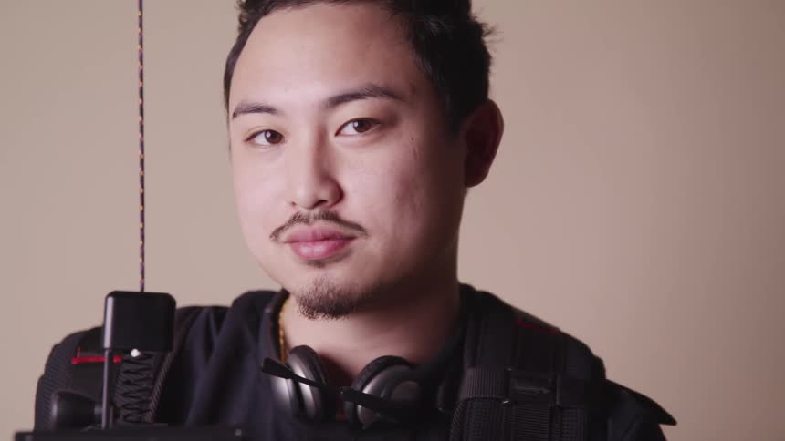 A man looks up with headphones hanging around his neck
