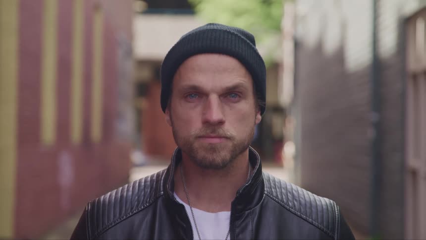 A man in a beanie staring at the camera
