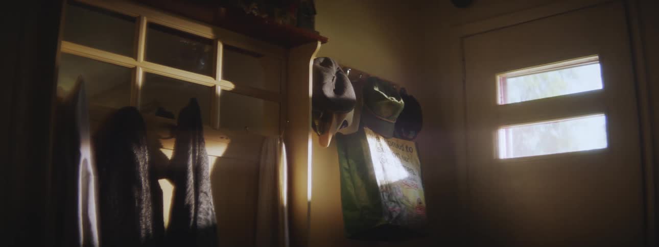 Jackets and hats hanging on hooks next to a front door