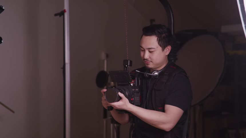 A photographer smiles as he looks through his camera lens