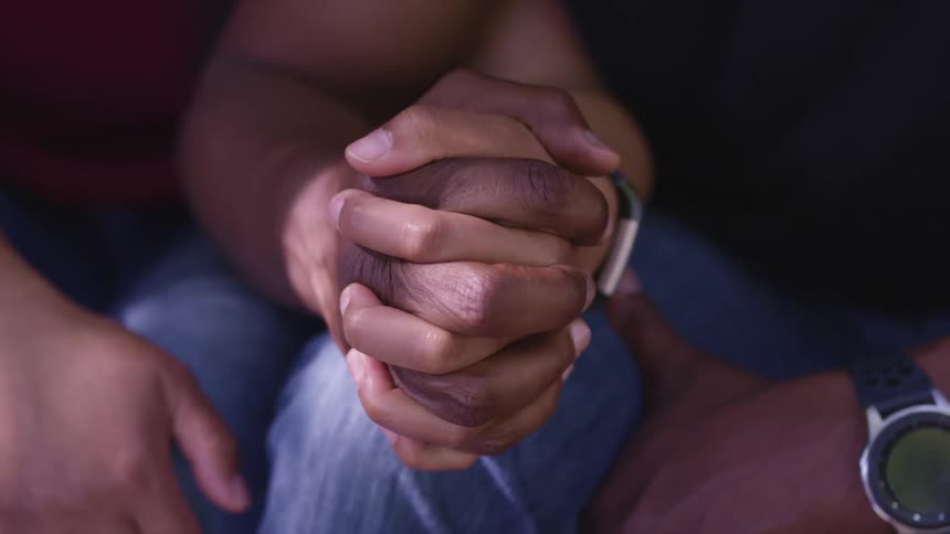 A man and woman are holding hands while sitting together