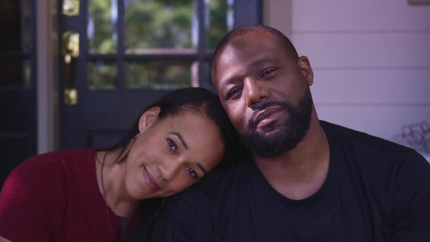 A woman is leaning her head on a mans shoulder