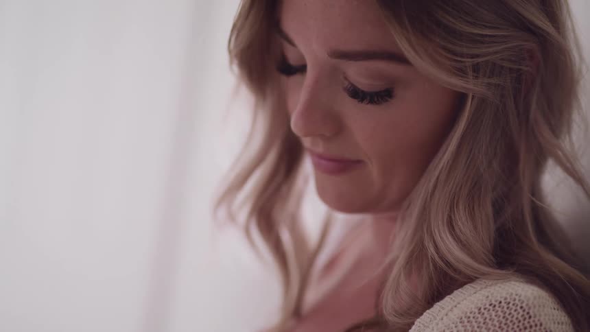 A womans eyelashes flutter as she looks up from gazing down lovingly
