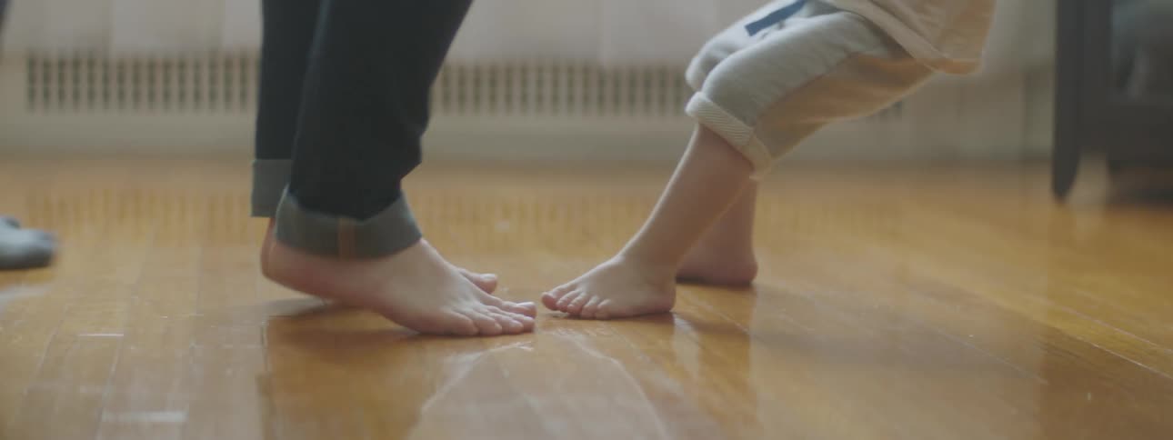 A boy dancing in a room with family