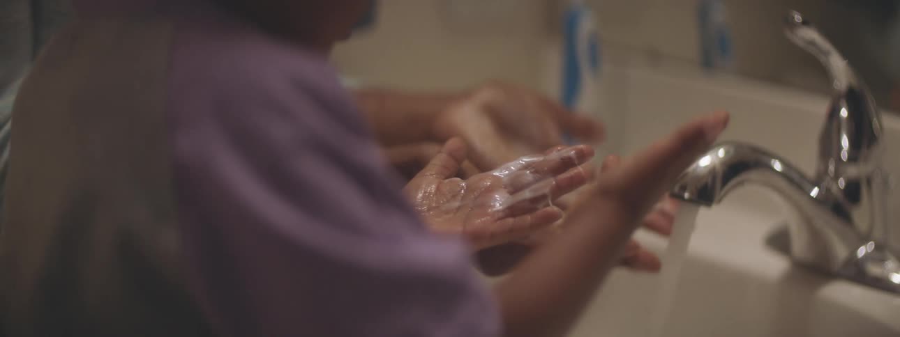 Mother teaches son to wash hands