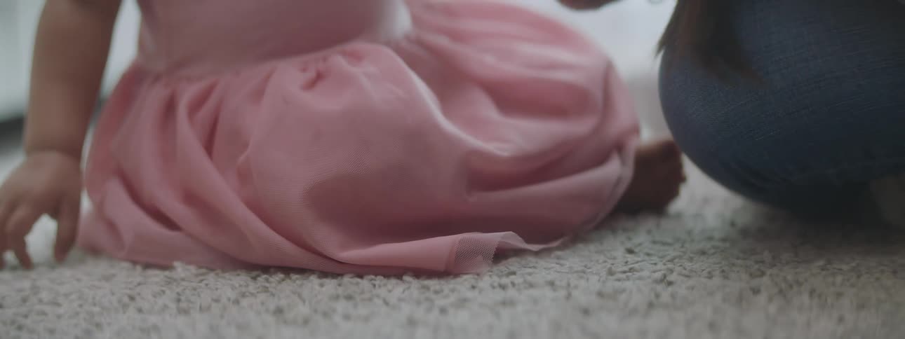 A woman sitting on the floor playing with a baby