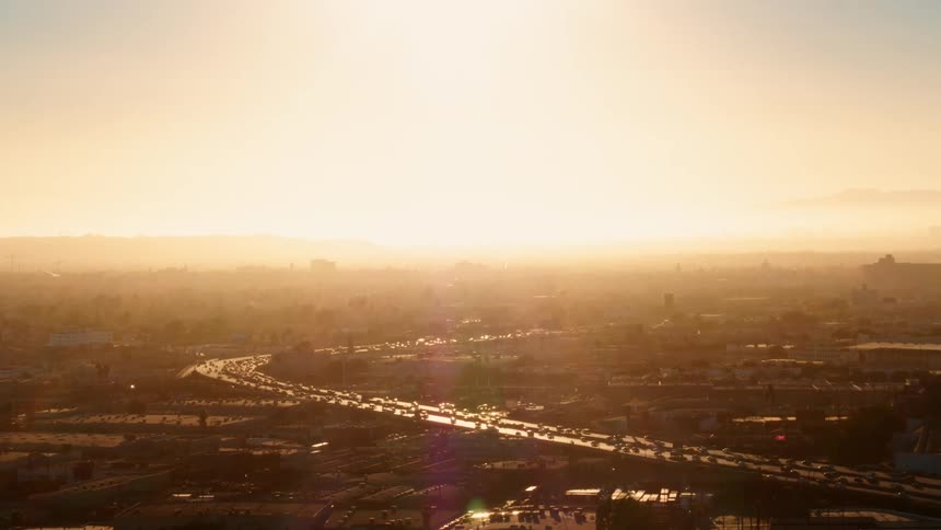 Busy highway traffic with bright sunlight shining on the city