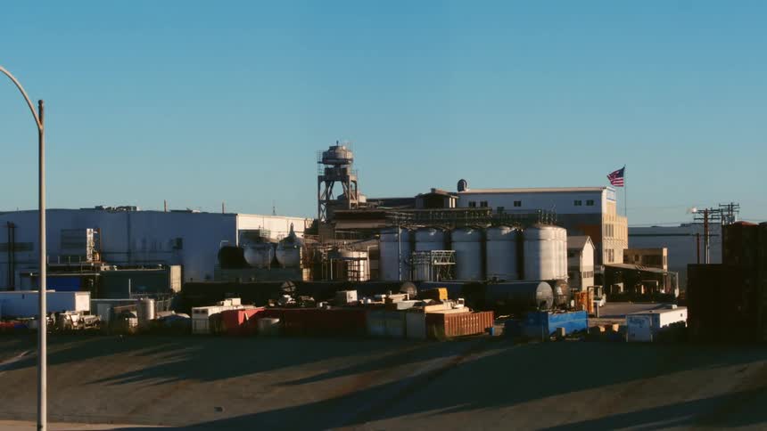 Aerial view of a factory next to a highway at daytime