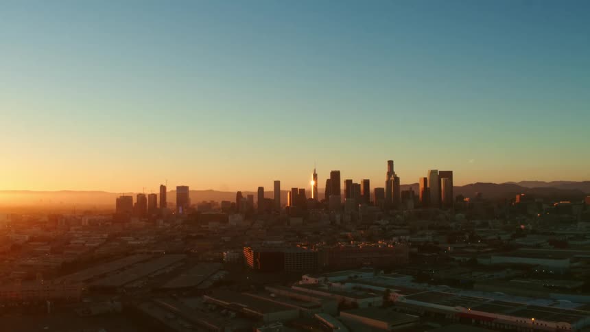 The sun is setting over the large city