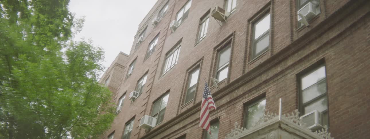 An apartment building with an american flag in a city area