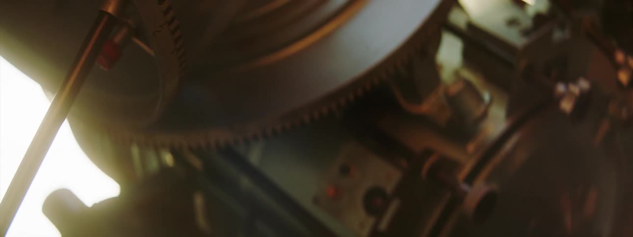 Close up of the turning gears of a moving machine machine