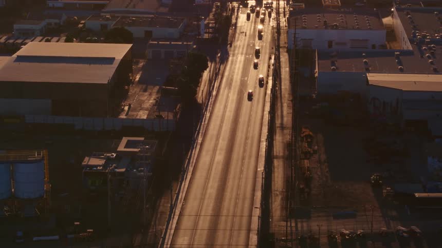 An aerial view of cars driving past factories