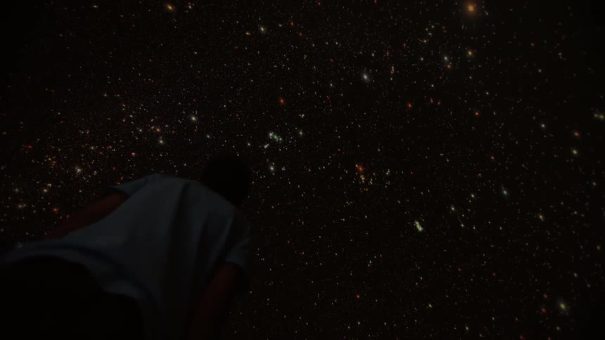 Night sky with many bright stars and a person looking at the sky