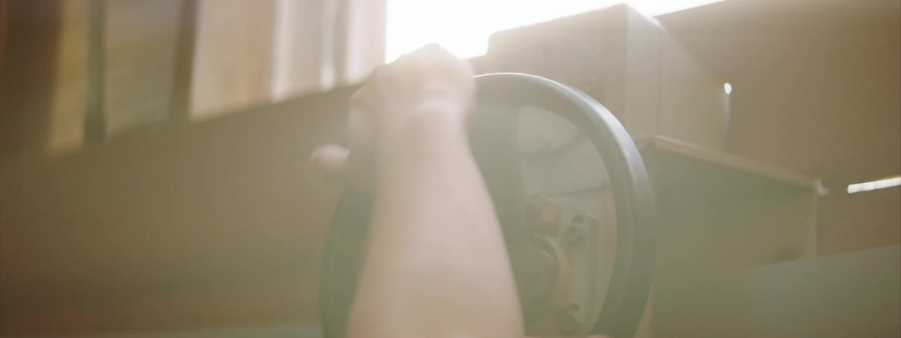A person is turning the wheel on a machine