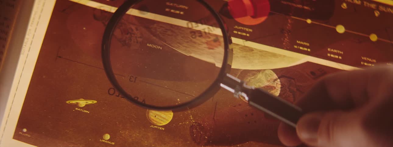 A person is examining a page with planets displayed on it