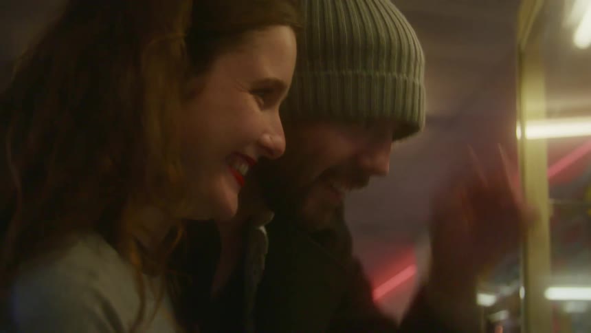 Two friends are playing arcade games indoors on a date