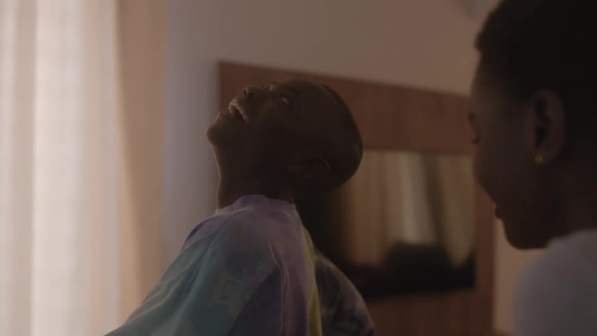 Two boys in a room with a wall a flat screen tv and a window in the background