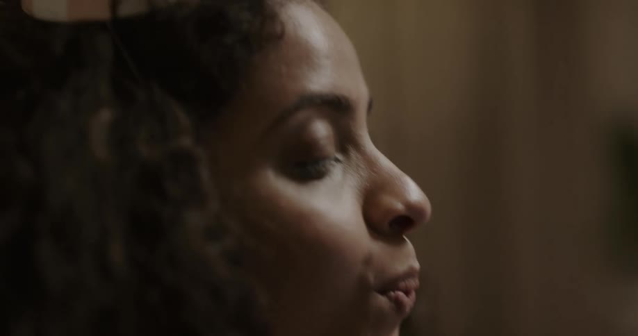 Young woman on a video call blowing candles of a cake for her birthday