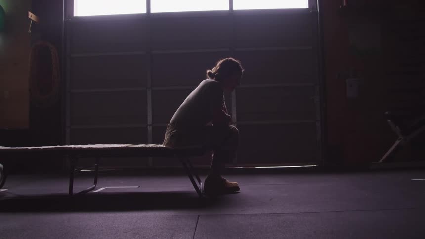 A woman sitting on a bed looking sad