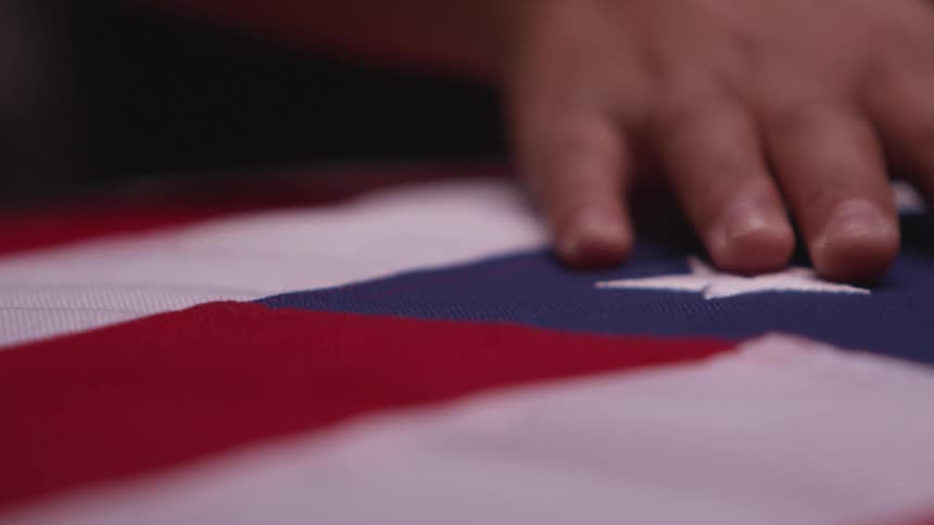 Person is moving their hand across an american flag