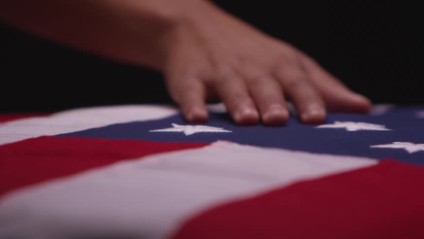 Person is moving their hand across an american flag