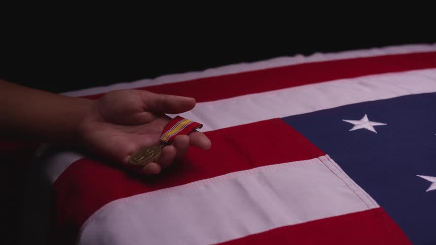 A person holding a medal on an american flag