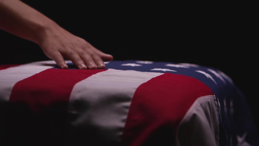 A person running their hand over an american flag