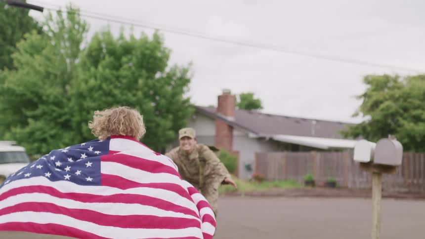 A daughter running towards her father in military clothing