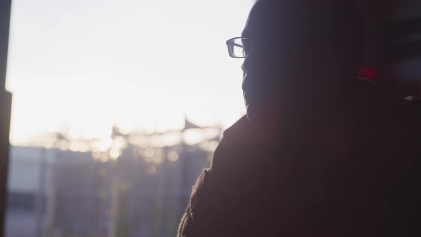 Silhouette of a soldier sitting inside a building at sunset